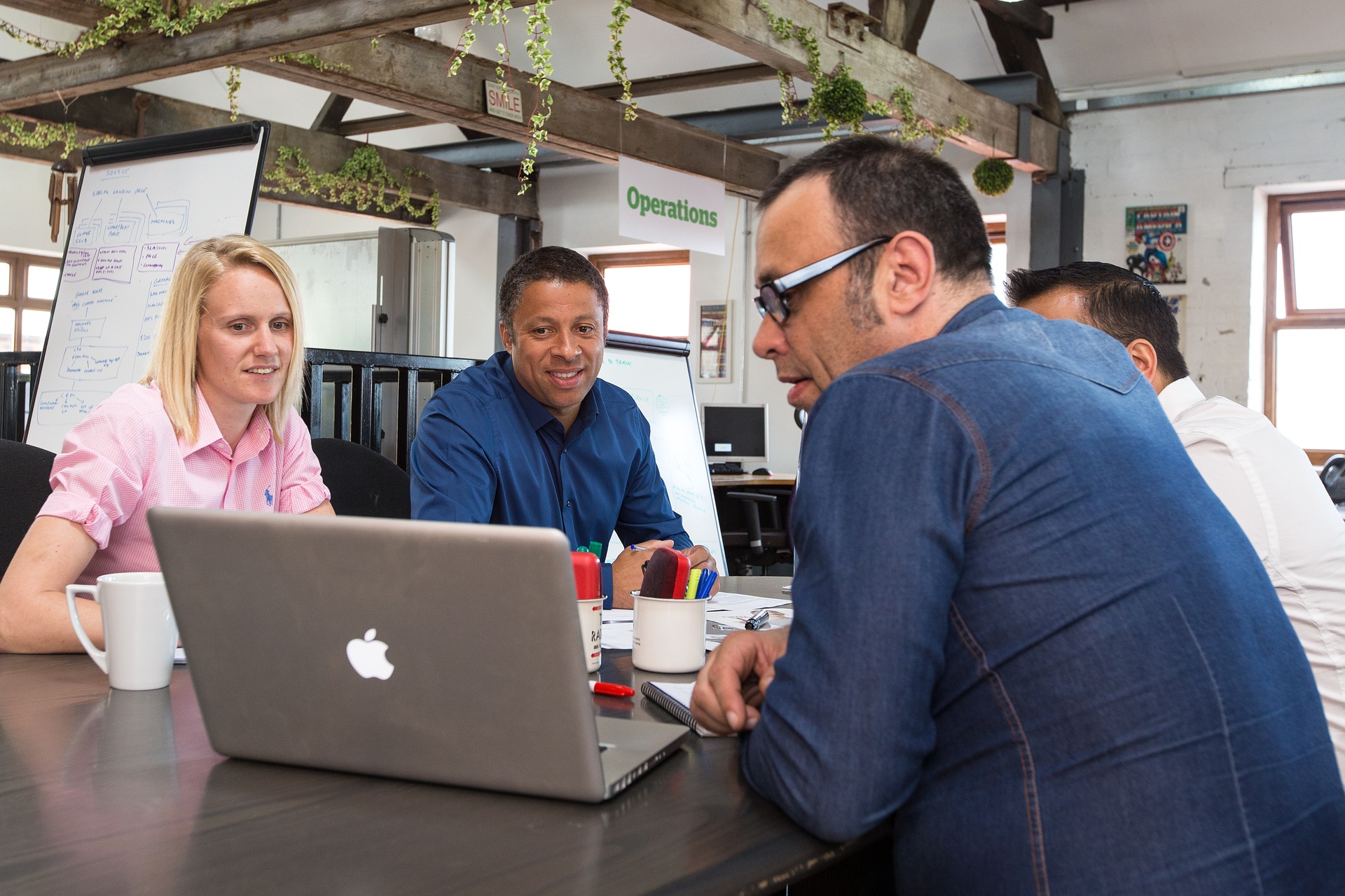 Group of people looking at laptop and chatting